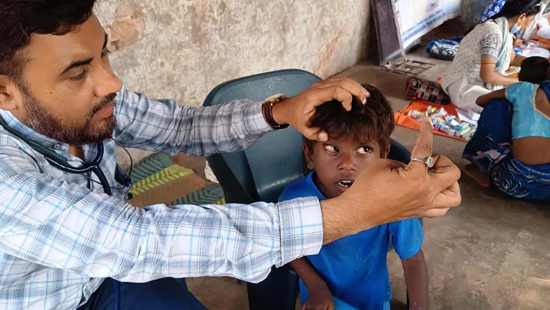 Un médecin examine un enfant lors d’une action de santé